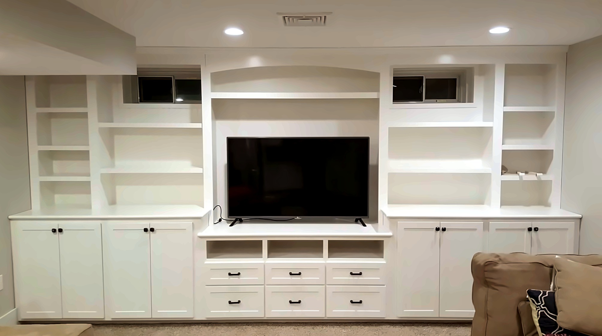 White built-in cabinetry and media storage in a finished room